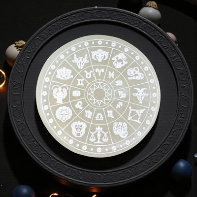Round selenite charging plate engraved with zodiac wheel for cleansing and recharging crystal bracelets