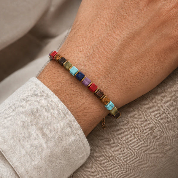 7 chakra bracelet with golden hematite worn on wrist, colourful cube beads on a man's arm
