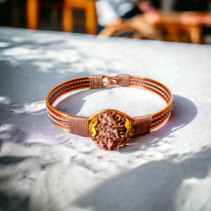 Nepali copper wire wrapped 7 Mukhi rudraksha bracelet on marble table, front view