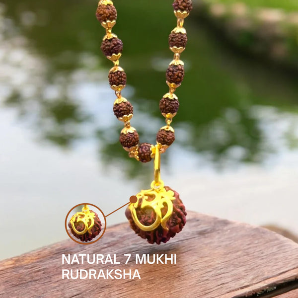 Close-up of the gold Om pendant over a natural 7 mukhi rudraksha bead with zoom detail
