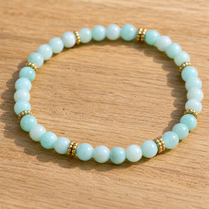 Close-up of the Amazonite 4mm Bead Bracelet with Gold Spacers on a light oak board