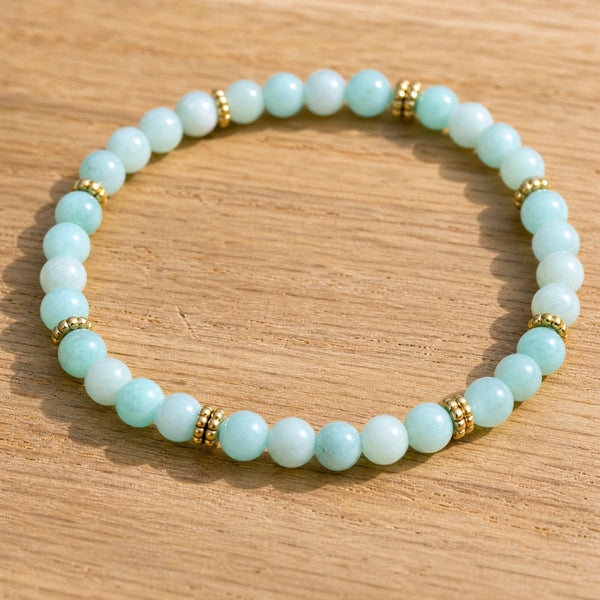 Close-up of the Amazonite 4mm Bead Bracelet with Gold Spacers on a light oak board