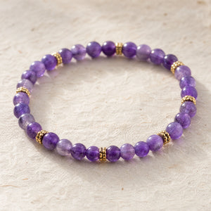Close-up of the Amethyst 4mm Bead Bracelet with Gold Spacers on cream handmade paper