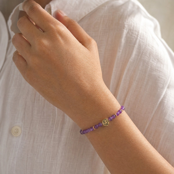 Woman wearing the Amethyst 4mm Bracelet with Om Charm with a white linen shirt