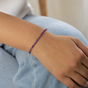 Woman wearing the Amethyst 4mm Round Bead Bracelet with blue denim
