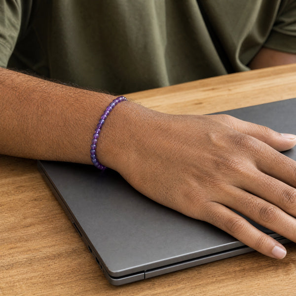 Man wearing the Amethyst bracelet, at a wooden desk