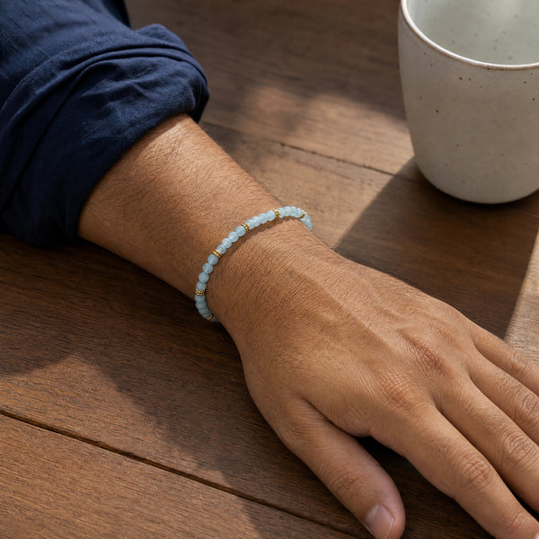 Man wearing the Aquamarine 4mm Bead Bracelet with Gold Spacers with a navy cotton shirt