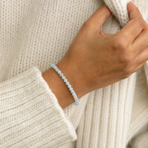 Woman wearing the Aquamarine 4mm Round Bead Bracelet with a cream knit cardigan