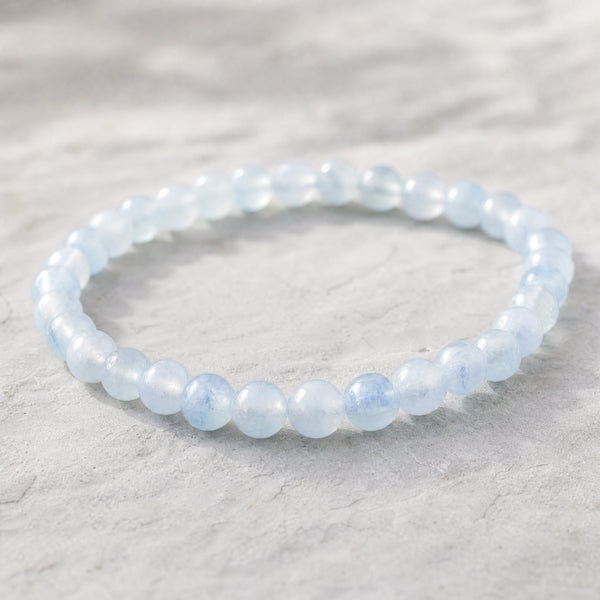 Close-up of the Aquamarine 4mm Round Bead Bracelet on a pale stone surface