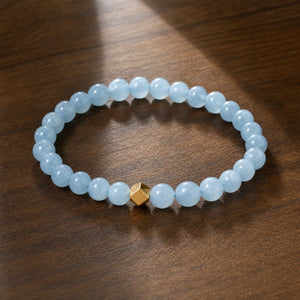 Soultheory Aquamarine 6mm Bead Bracelet with Gold Accent on dark walnut wood
