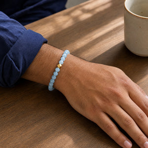 Man wearing the Aquamarine 6mm Bead Bracelet with Gold Accent with a navy cotton shirt