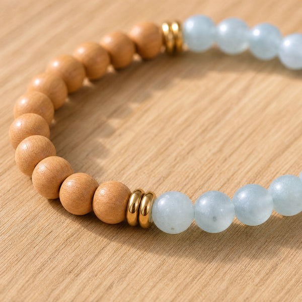 Close-up of the Aquamarine & Rosewood 6mm Bead Bracelet on a light oak board