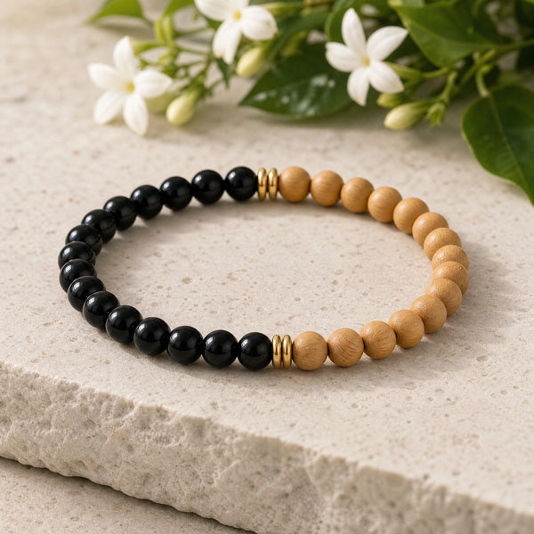 Soultheory Black Onyx & Rosewood 6mm Bead Bracelet on a limestone plinth with jasmine