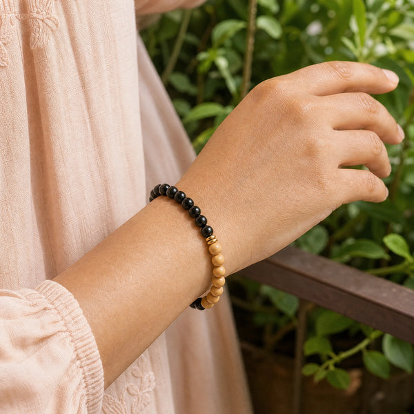 Woman wearing the Black Onyx & Rosewood 6mm Bead Bracelet with a peach cotton top