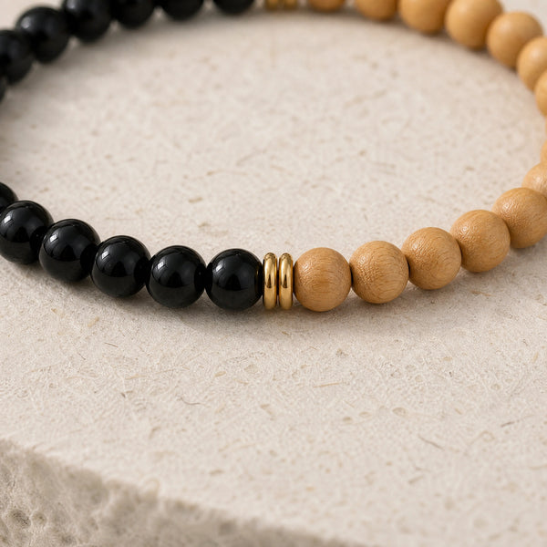 Close-up of the Black Onyx & Rosewood 6mm Bead Bracelet on cream handmade paper