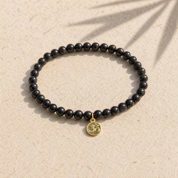 Soultheory Black Tourmaline 4mm Bracelet with Om Charm on cream handmade paper