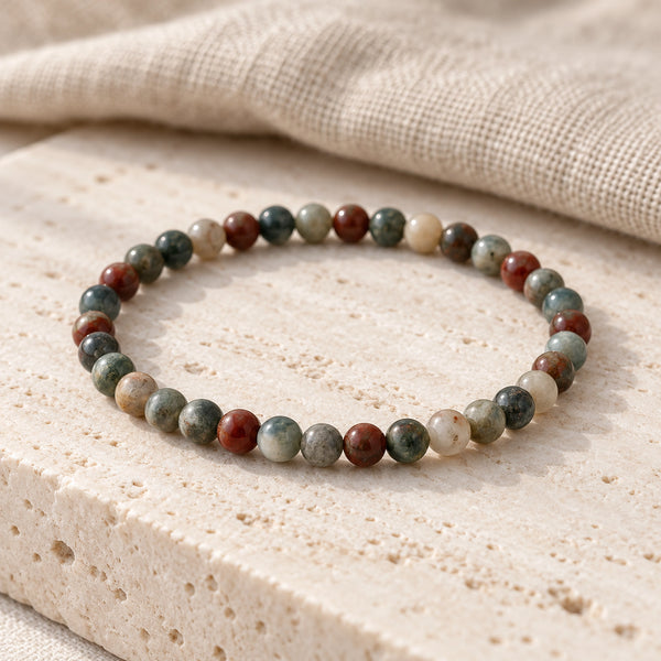 Soultheory Bloodstone 4mm Round Bead Bracelet on a travertine slab and linen