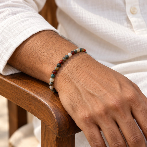 Man wearing the Bloodstone 4mm Round Bead Bracelet with a white kurta