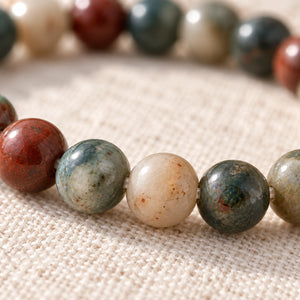 Close-up of the Bloodstone 4mm Round Bead Bracelet on natural linen
