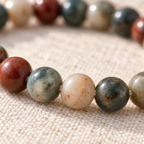 Close-up of the Bloodstone 4mm Round Bead Bracelet on natural linen