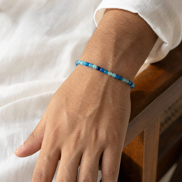 Man wearing the Blue Agate 4mm Round Bead Bracelet with a white kurta