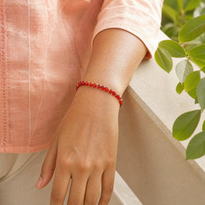Woman wearing the Carnelian 4mm Bead Bracelet with Gold Spacers with a peach cotton top