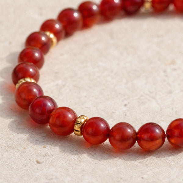 Close-up of the Carnelian 4mm Bead Bracelet with Gold Spacers on cream handmade paper