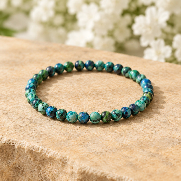 Soultheory Chrysocolla 4mm Round Bead Bracelet on a sandstone block with white flowers