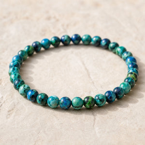 Close-up of the Chrysocolla 4mm Round Bead Bracelet on a pale stone surface