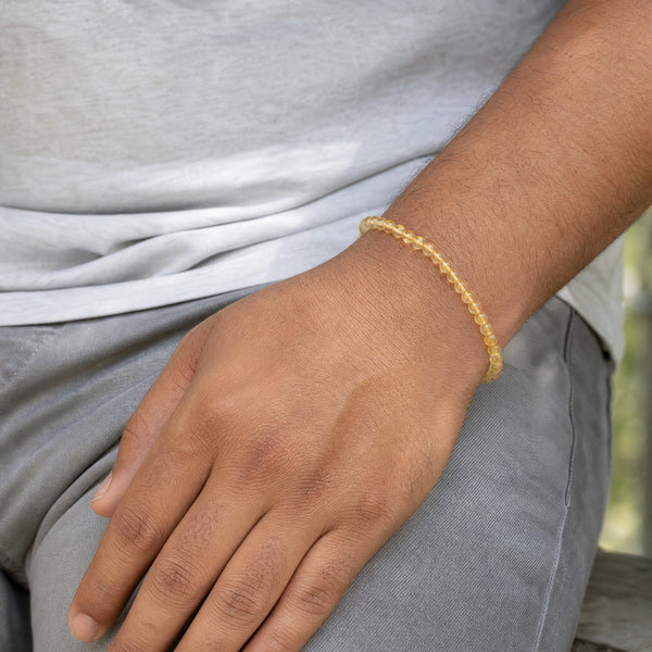 Man wearing the Citrine 4mm Round Bead Bracelet with a grey t-shirt