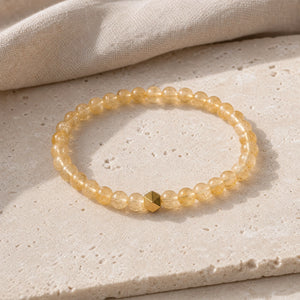 Soultheory Citrine 6mm Bead Bracelet with Gold Accent on a travertine slab and linen
