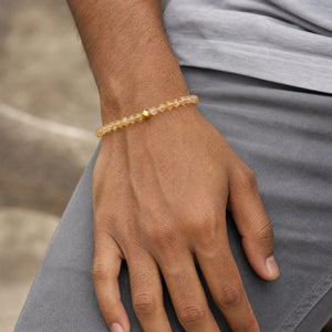 Man wearing the Citrine 6mm Bead Bracelet with Gold Accent with a grey t-shirt