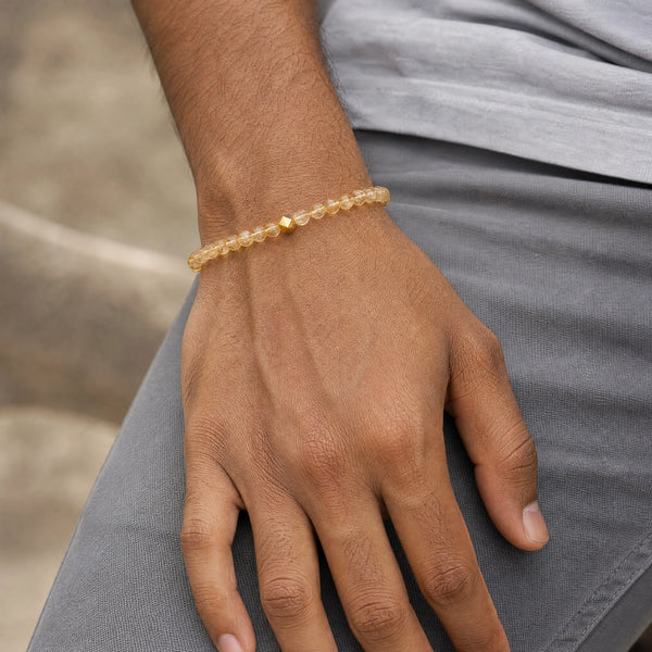 Man wearing the Citrine 6mm Bead Bracelet with Gold Accent with a grey t-shirt