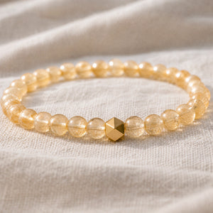 Close-up of the Citrine 6mm Bead Bracelet with Gold Accent on natural linen