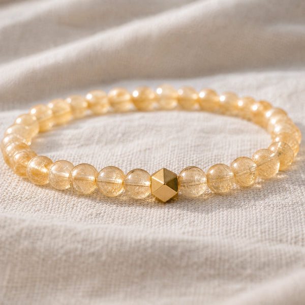 Close-up of the Citrine 6mm Bead Bracelet with Gold Accent on natural linen