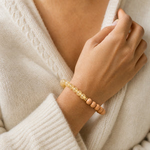 Woman wearing the Citrine & Rosewood 6mm Bead Bracelet with a cream knit cardigan