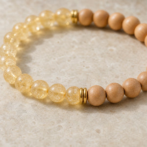 Close-up of the Citrine & Rosewood 6mm Bead Bracelet on a pale stone surface