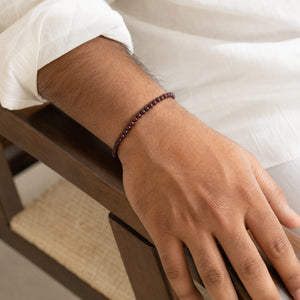 Man wearing the Garnet 4mm Round Bead Bracelet with a white kurta