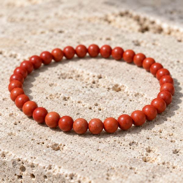 Close-up of the Goldstone 4mm Round Bead Bracelet on pale travertine