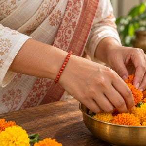 Woman wearing the Goldstone bracelet, arranging marigold flowers
