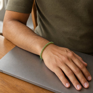 Man wearing the Green Jade bracelet, at a wooden desk