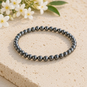 Soultheory Hematite 4mm Bead Bracelet on a limestone plinth with jasmine