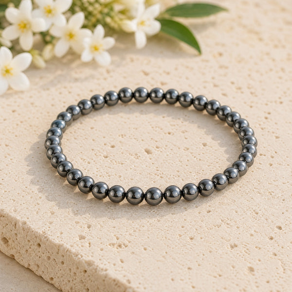 Soultheory Hematite 4mm Bead Bracelet on a limestone plinth with jasmine