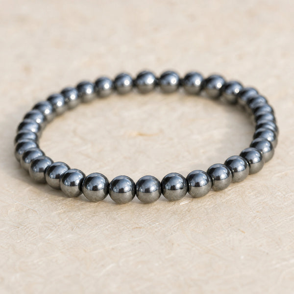 Close-up of the Hematite 4mm Bead Bracelet on cream handmade paper