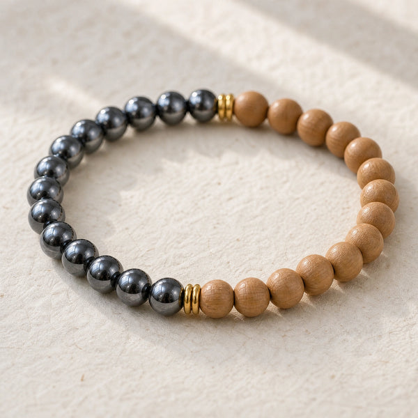 Close-up of the Hematite & Rosewood 6mm Bead Bracelet on cream handmade paper