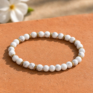 Soultheory Howlite 4mm Bead Bracelet with Gold Spacers on a terracotta tile with jasmine