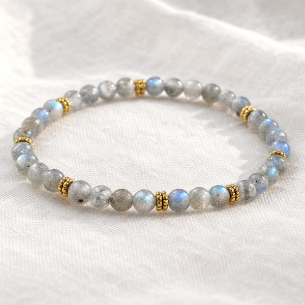 Close-up of the Labradorite 4mm Bead Bracelet with Gold Spacers on white linen