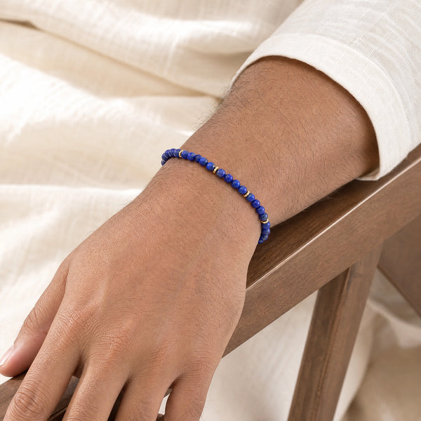 Man wearing the Lapis Lazuli 4mm Bead Bracelet with Gold Spacers with a white kurta