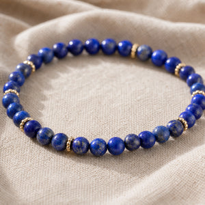 Close-up of the Lapis Lazuli 4mm Bead Bracelet with Gold Spacers on natural linen