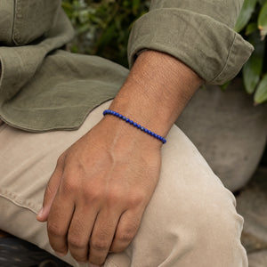 Man wearing the Lapis Lazuli 4mm Round Bead Bracelet with an olive linen shirt